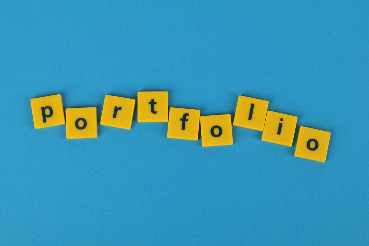 hero-img-01 Yellow Scrabble tiles on a blue background spelling portfolio. Perfect for business themes.